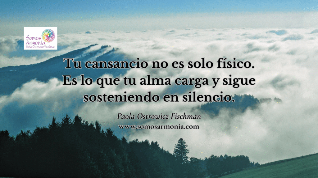 Energía bloqueada y cansancio no físico. Imagen con frase: Tu cansancio no es solo físico. Es lo que tu alma carga y sigue sosteniendo en silencio. Paisaje de montañas, nubes y bosque que simboliza la liberación interior de Somos Armonía.